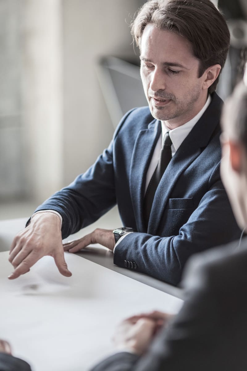 Abogado de empresas asesorando a un cliente en una sala de juntas corporativa